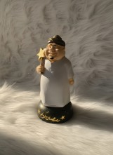 تمثال زينة رمضان كريم، شخصية كرتونية بثوب أبيض وعمامة ذهبية تحمل نجمة، قاعدة سوداء مزينة بنجوم ونص رمضان كريم، ديكور إسلامي